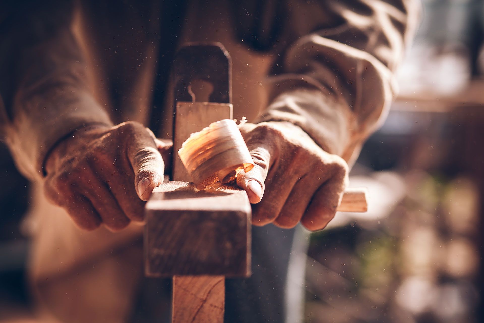 Ein Tischler hobelt ein Stück Holz